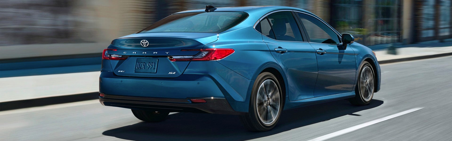 A blue car driving on the road.