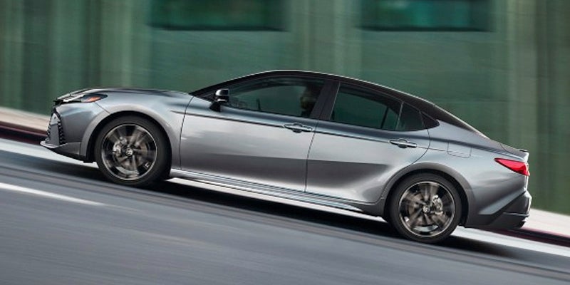 A silver car driving on the road.