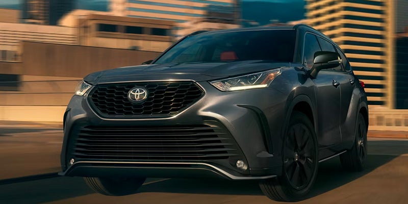 A silver suv driving on the road.