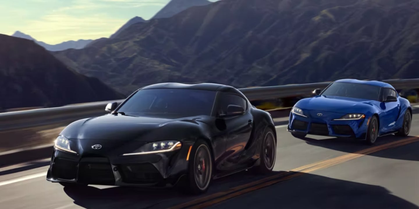 Black and blue Toyota Supra sports cars driving on the highway.