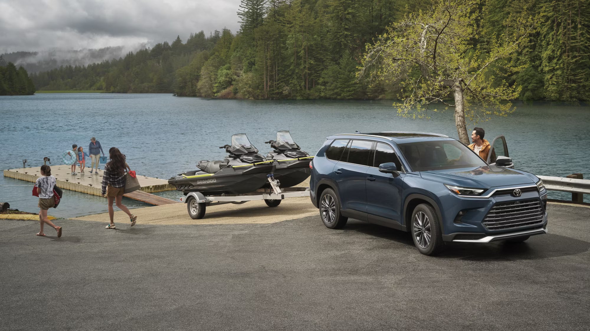 A blue suv pulling two jet skis.