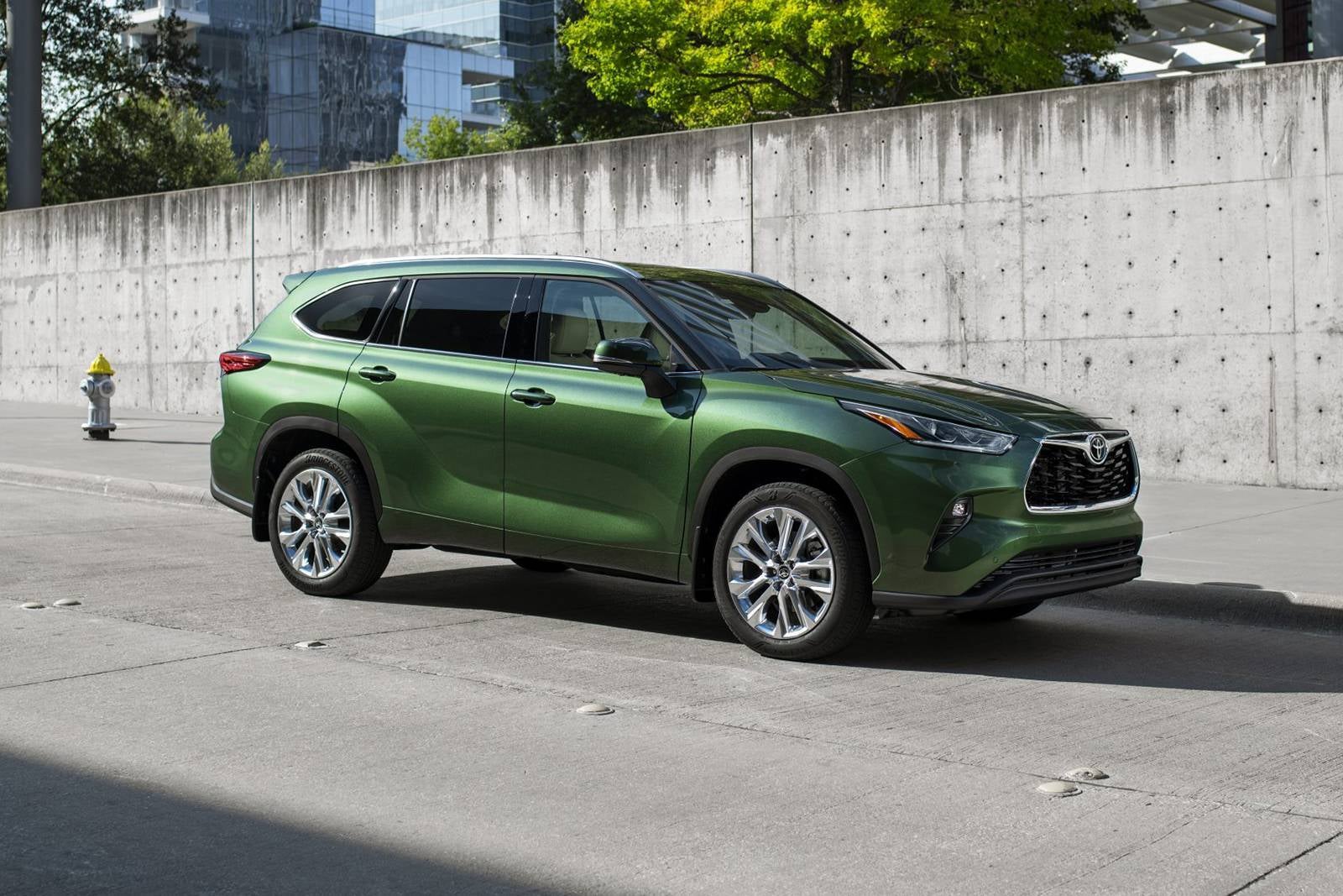 A green suv parked on the side of the road.