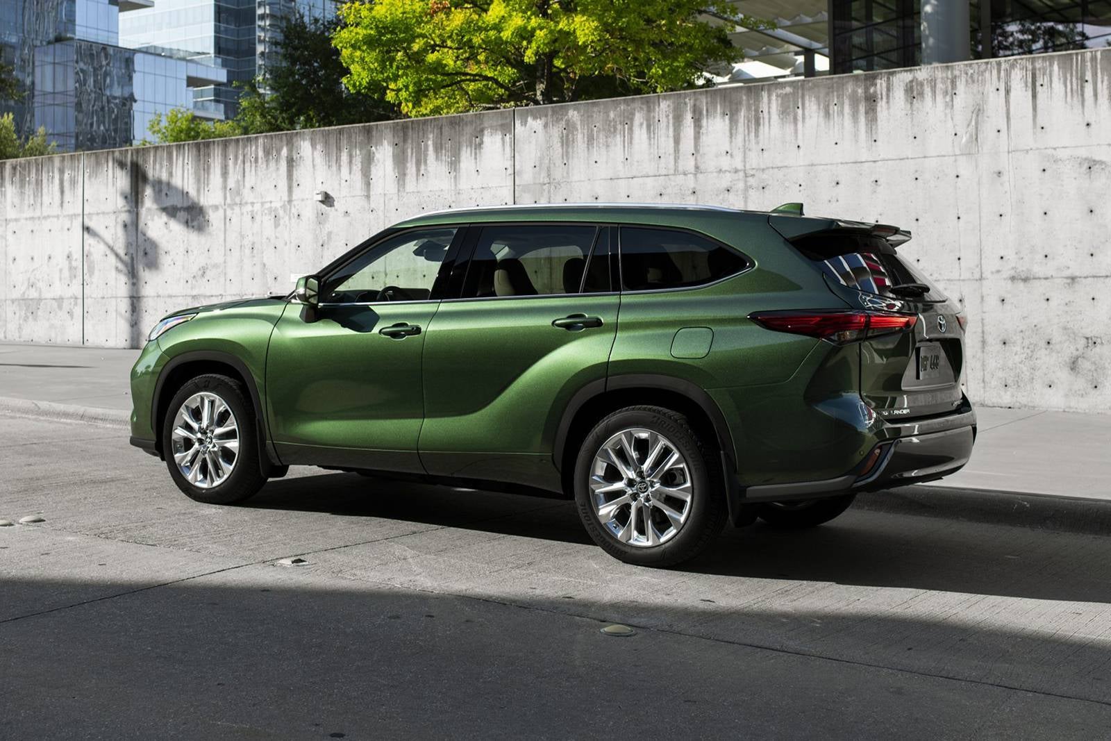 A green suv parked on the side of the road.