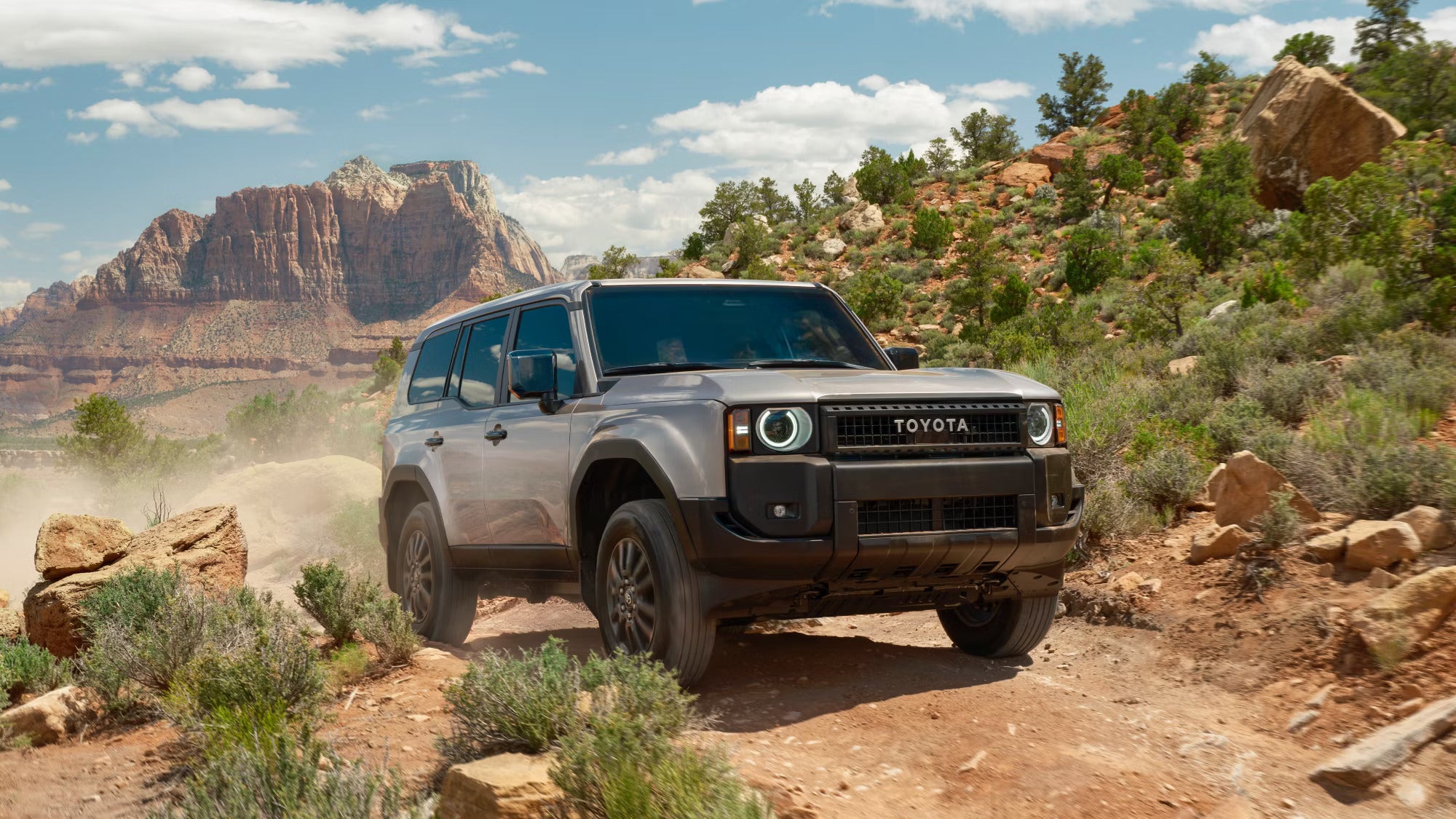 A gray suv driving up a hill.
