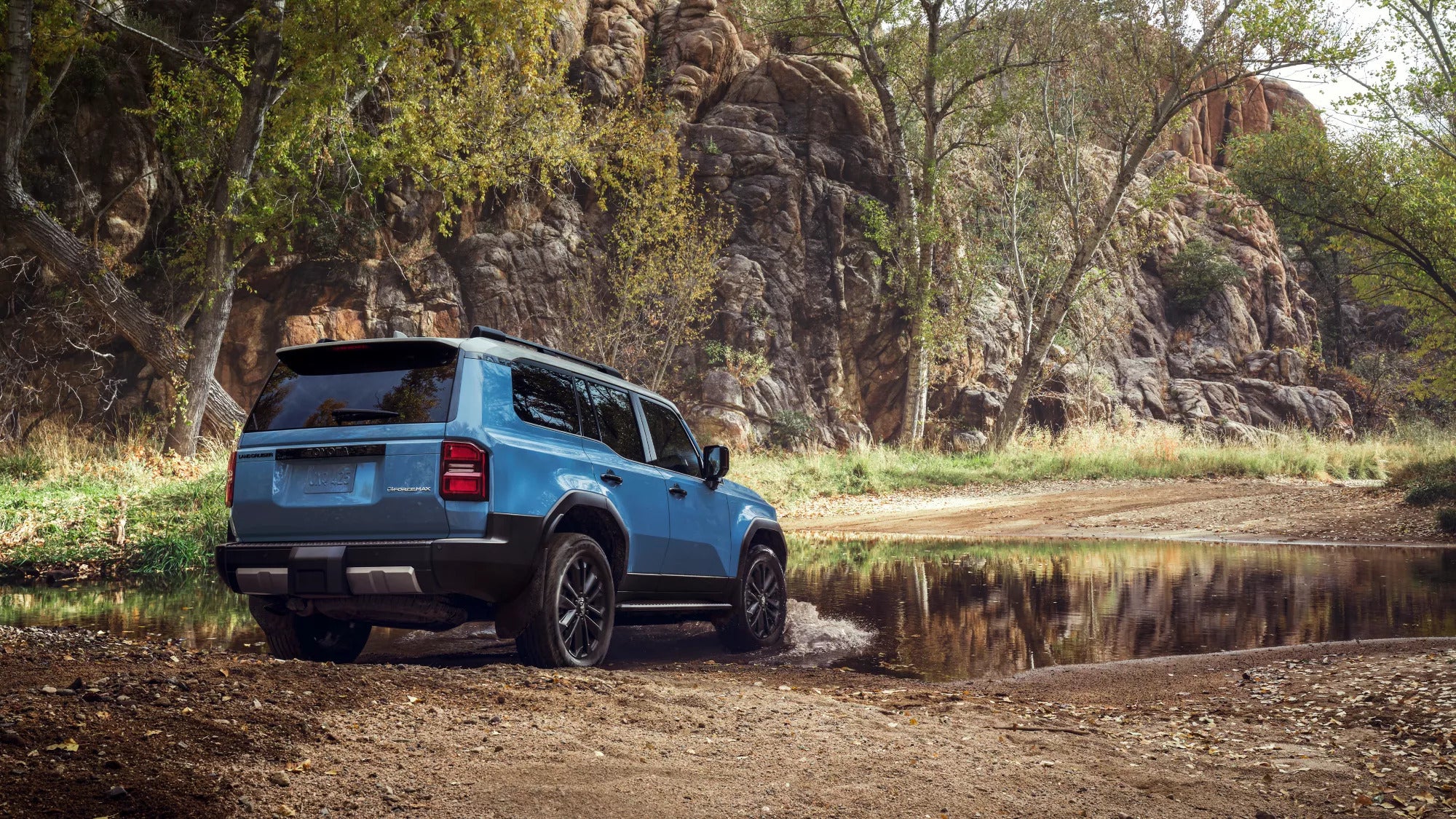 A blue suv going through some water.