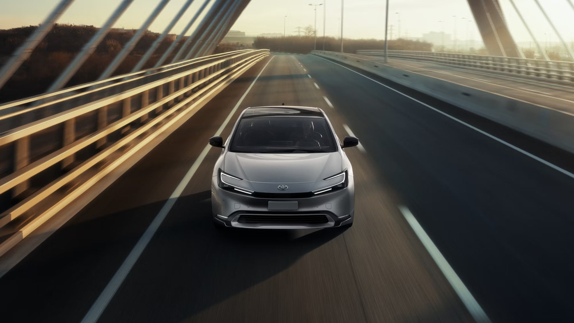 A gray car driving on a highway.