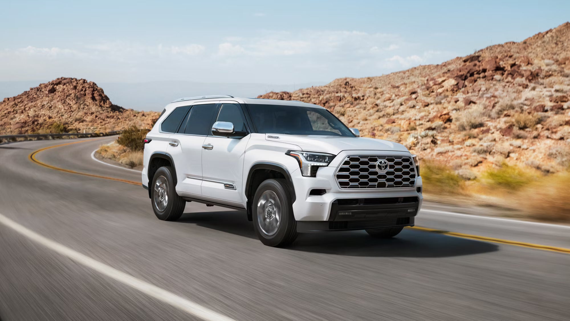 A white suv driving on the road.