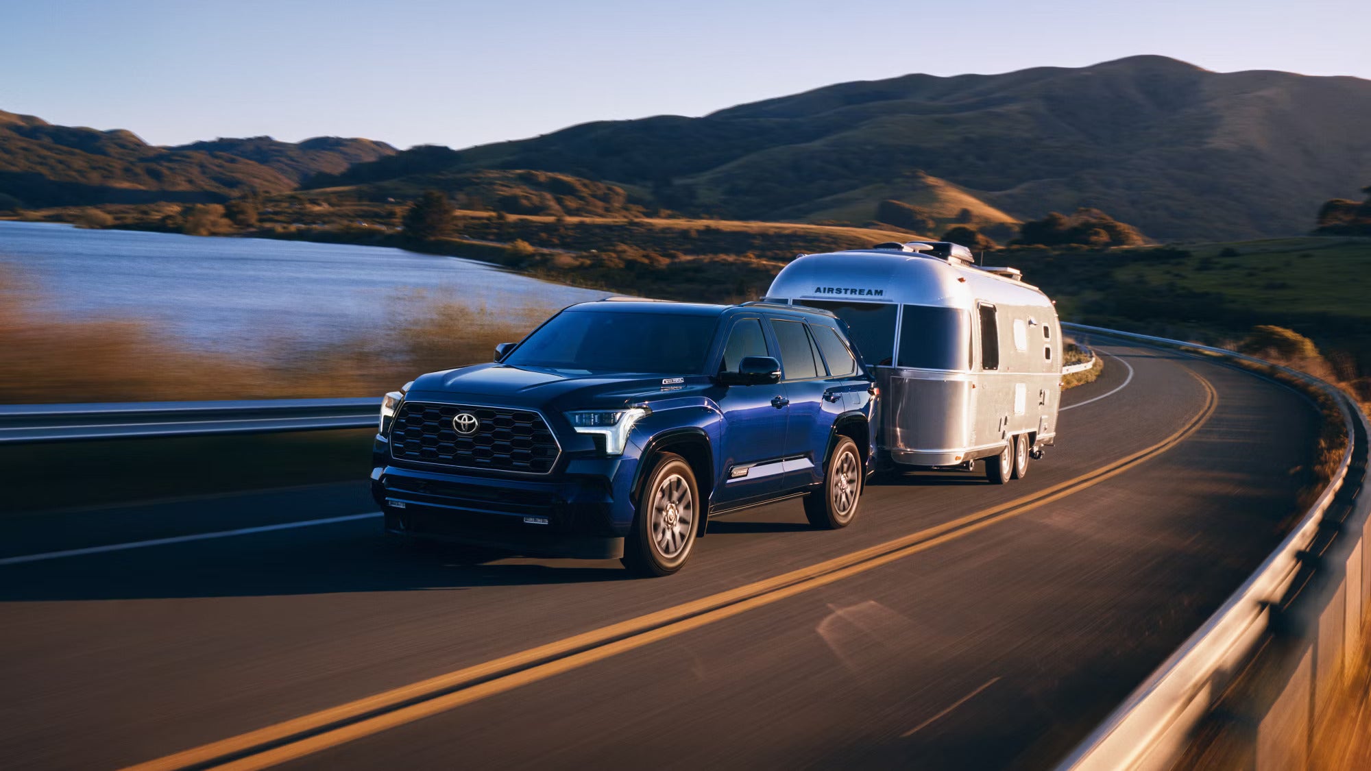 A blue suv pulling a trailer.