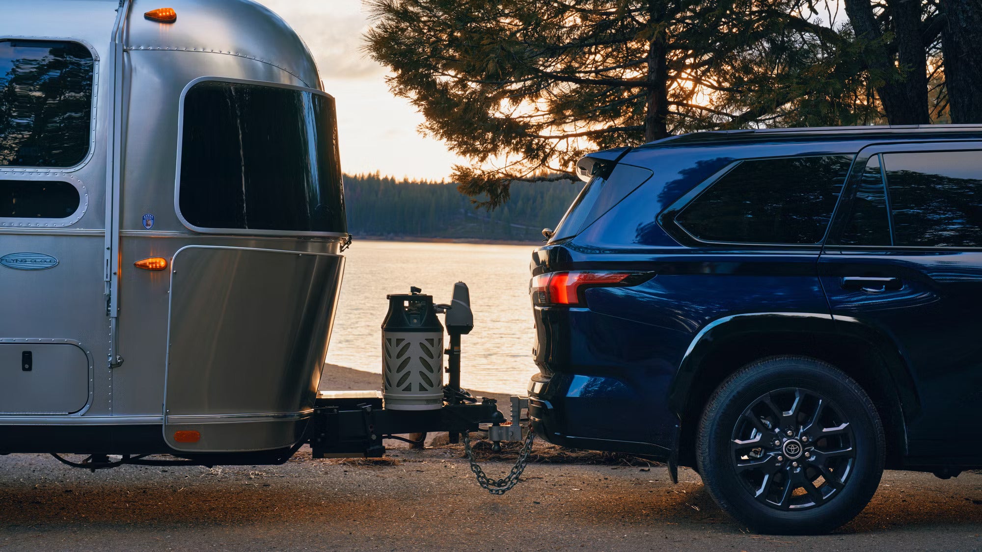 A blue suv with a trailer attached.