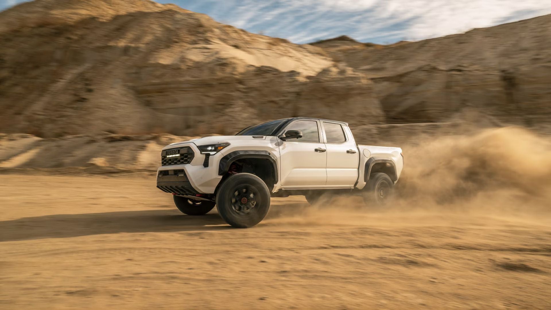 A white truck driving off-road.