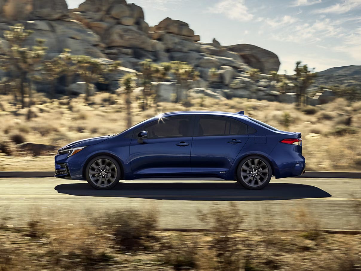 A blue car driving on the road.