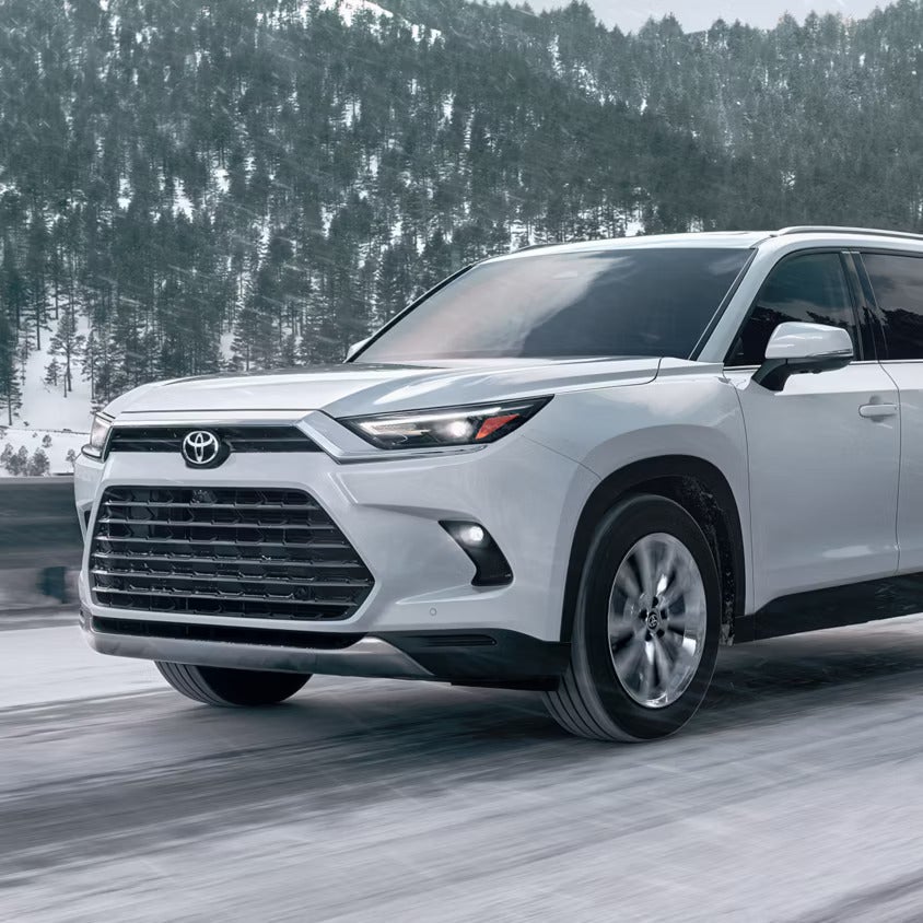 A white suv driving on the road.