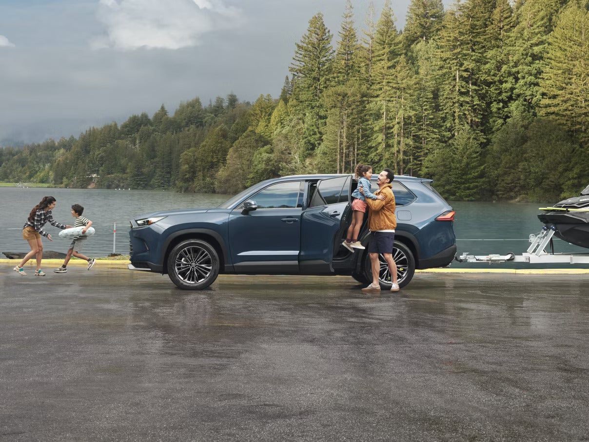 A family around a blue suv.