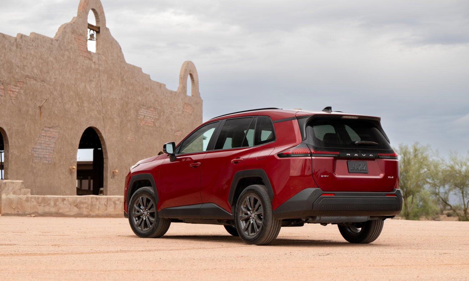 A red suv sitting parked off-road.