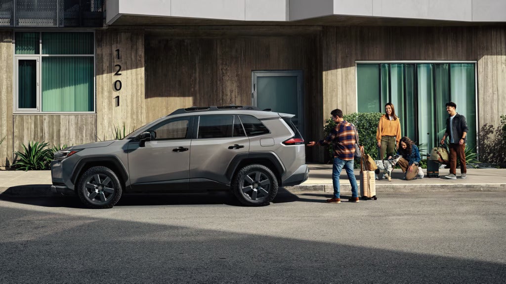 A family next to a gray suv.