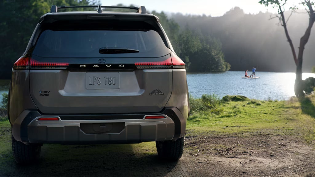A gray suv parked next to some water.