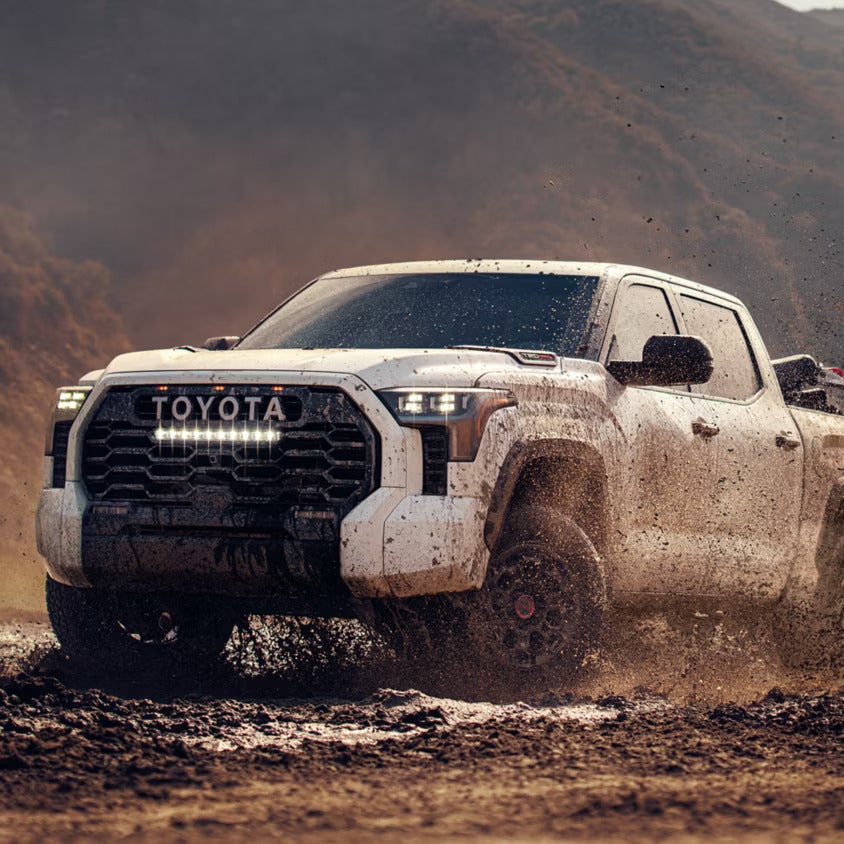A white truck covered in mud.