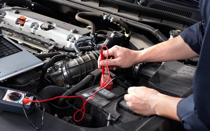 a service technician checking the battery on a vehicle
